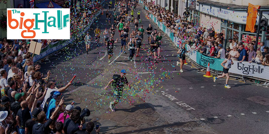 Ambiance festive avec des confettis et spectateurs encourageant les participants du Big Half dans les rues de Londres.