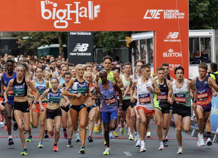 Départ de l'élite masculine et féminine du Big Half sous la grande arche de départ orange.